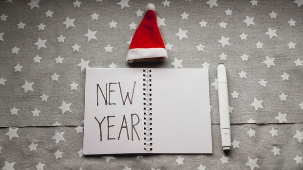 Notebook with pen to write goals of new year on christmas background