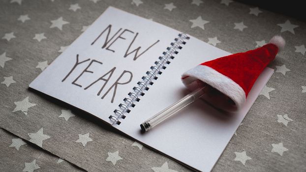 Notebook with pen to write goals of new year on christmas background