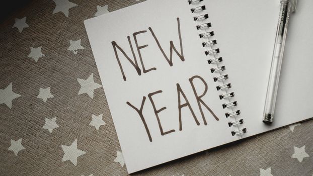 Notebook with pen to write goals of new year on christmas background