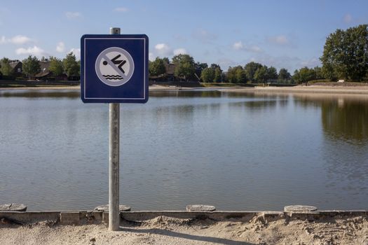 A no swimming danger sign at a lake