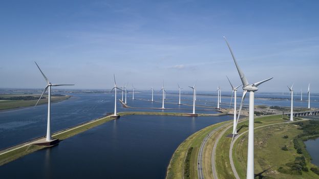 A Modern Wind Farm consisting of Wind Turbines with Two and Three Blades along the Shore of Grevelingenmeer under a Blue Sky in the Netherlands