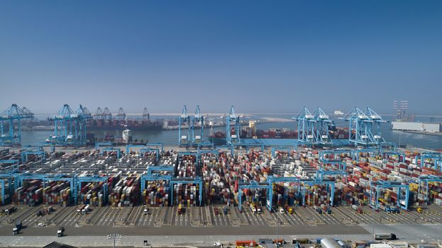 Large harbor cranes loading container ships in the port of Rotterdam