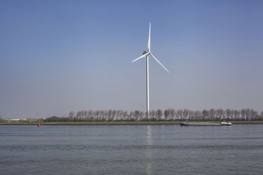 Netherlands, New Waterway. Container ship in front of modern windmill shipping, transport and heavy industry nera Maasvlakte 2.