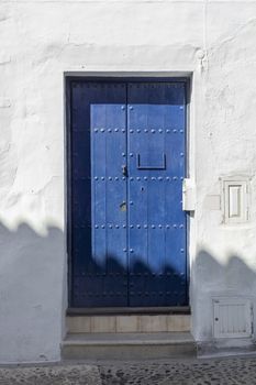 Vintage window and blue door on old traditional house in Andalusia, Spain