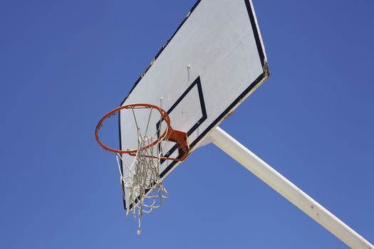 Outdoor basketball hoop against a blue sky - street basketball