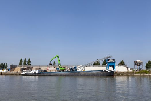 Loading barge with sand and rubble on a small berth. Freight transport logistics
