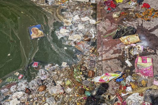 Pollution on a river. Plastic garbage, foam, wood and dirty waste on a river shore