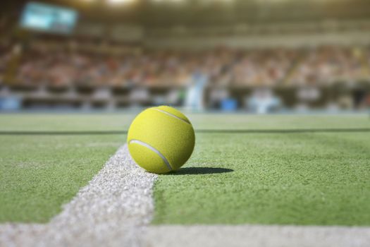 Tennis court background with audience out of focus and close up from a yellow tennis ball