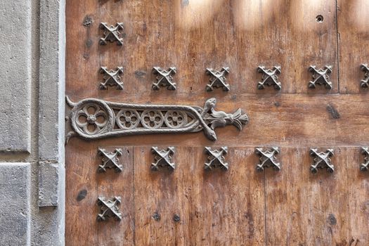 Traditional old wooden door in Andalusia, Spain. Use of nails and metal at the old wooden door. Texture