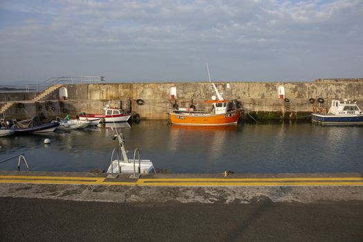 Old fishing boats docked in a small coastal port, Ireland. Europe