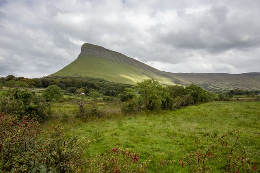 Typical Irish landscape with dark grey clouds, rain and mountains -  Image