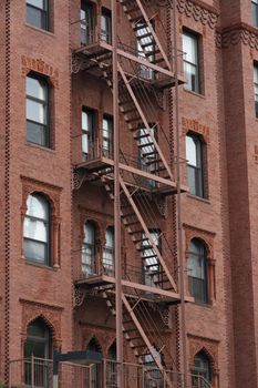 Red Fire escape stairs-downtown back alley architecture-steel and red brick background