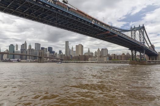 View of Lower Manhattan and Brooklyn Bridge skyline on a sunny summer day from Brooklyn's side of East River. Wall Street Financial district skyscrapers in the background