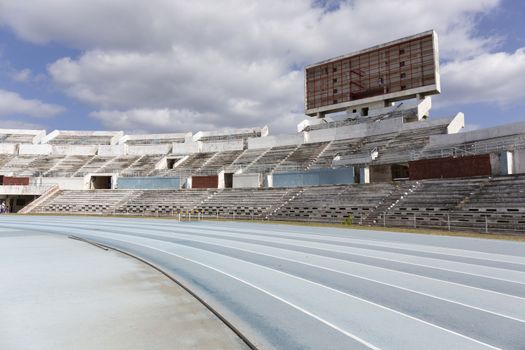 Old athletic stadium. Running healthy lifestyle concept. Blue sport track for running on stadium with tribune