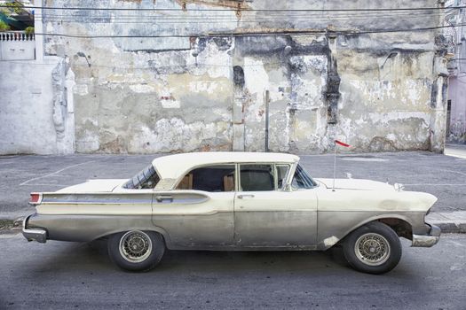 A grey and green American car still running on the streets of Cuba.
