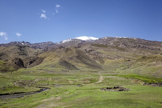 road in the high Atlas Mountains in Morocco, in the center of a small stone destroyed building