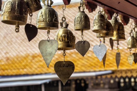 Many golden buddhist bells with wishes in sunlight