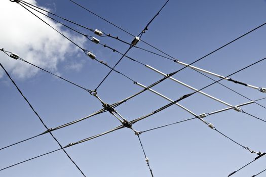 High-voltage electricity wires against blue sky