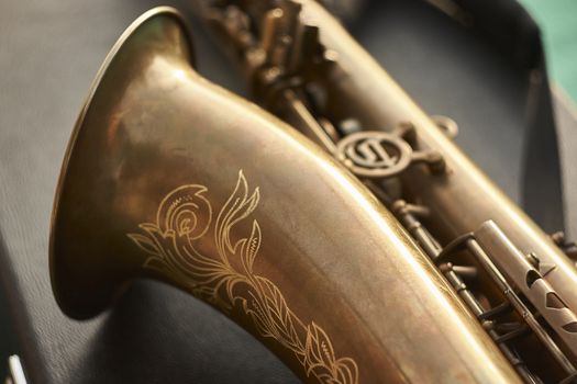 Detail of the trumpet of a brass saxophone. A musical instrument used by a rock band.