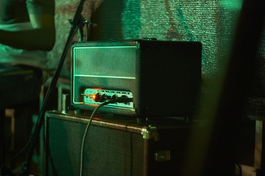 Detail of an electric guitar amp resumed in a live rock concert.