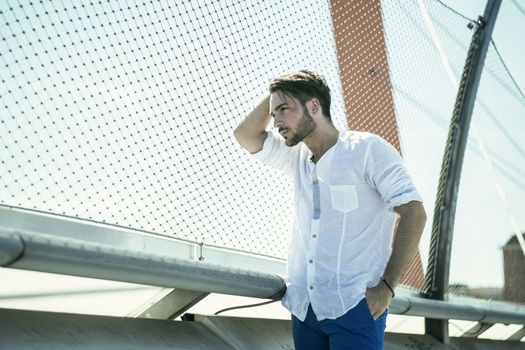 One handsome young man in urban setting in European city, standing
