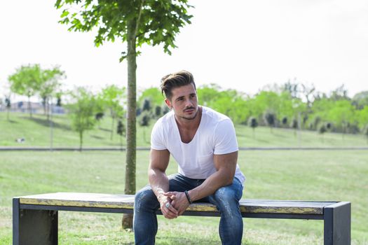 Attractive muscular man in city park in a nice summer day