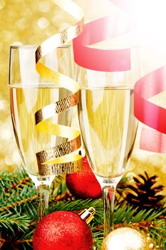 Champagne, fir tree, christmas decor and gifts on golden background