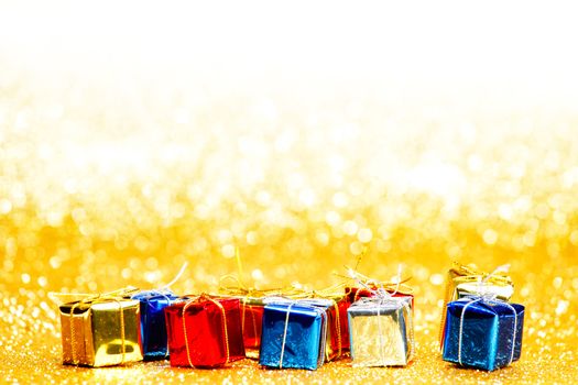 Colorful gift boxes on glitter golden background