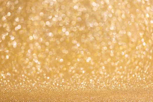 Golden festive glitter background with defocused lights