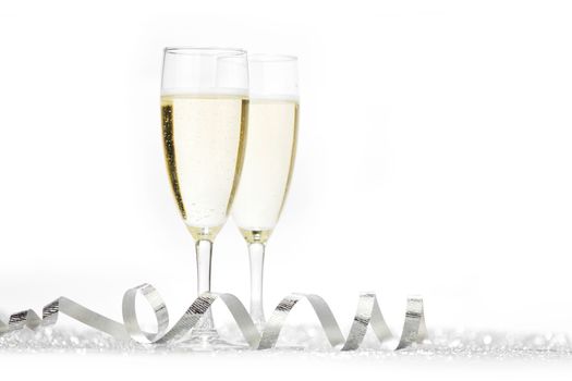 Two champagne glasses and silver shiny glitters isolated on white background