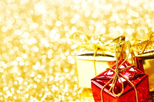 Decorative boxes with holiday gifts on abstract gold background