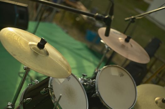 View of a drums, musical instrument, from the point of view of the player, shot in a stage ready for a live concert of a rock band.