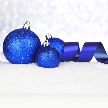 Blue Christmas decorations on snow close-up