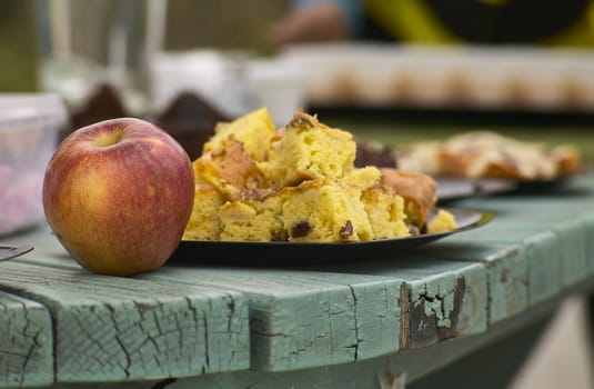 A red apple and a plate with a slice of sweet: a healthy and natural snack typical of the northern regions of Italy. Organic and natural sweet food.