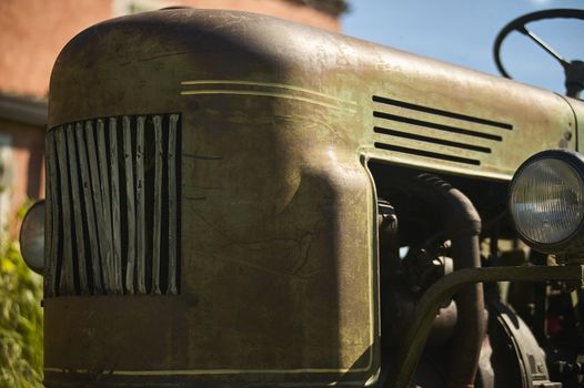 Detail of Old vintage tractor worn and with signs of time in a field ready for another hard day's work