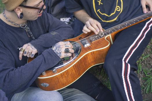 Play the guitar at the park for enjoying