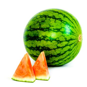 A whole organic mini watermelon with small piece cutouts isolated on white background.