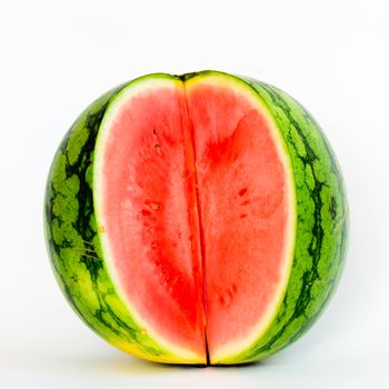 Cutout organic mini watermelon with three long slice cuts isolated on white background.