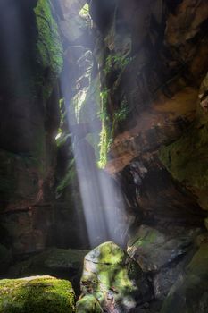 Light beams stream through like spot lights into the canyon