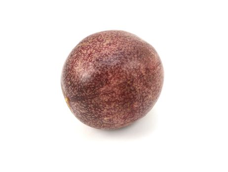 Whole passion fruit with speckled deep purple skin, on a white background