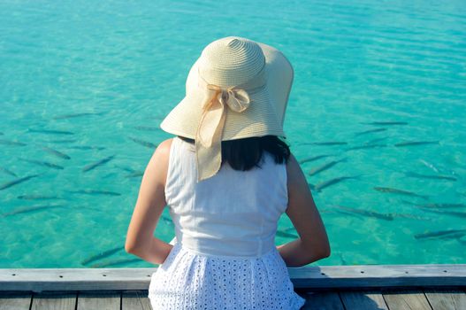 Beautiful asian woman in sunhat sitting and  relaxed at tropical beach in Maldives