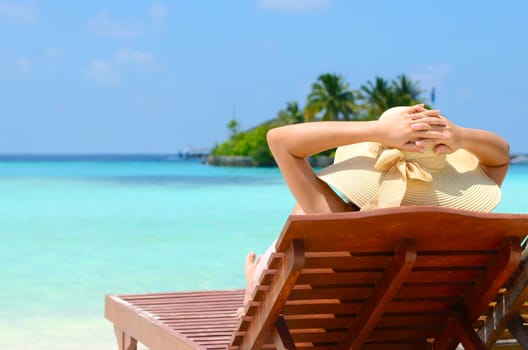 Beautiful girl on sunbed relaxing  at tropical  Maldives island. Travel and Vacation. 