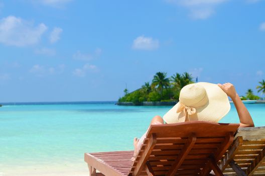 Woman on sunbed relaxing  at tropical  Maldives island. Travel and Vacation. 