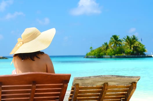Woman on sunbed relaxing  at tropical  Maldives island. Travel and Vacation. 