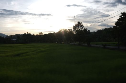 A colorful sunup above a small train station in thailand 