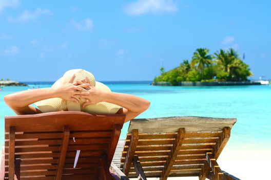 Woman on sunbed relaxing  at tropical  Maldives island. Travel and Vacation. 