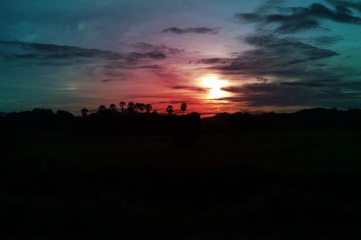 A colorful sunup above a small train station in thailand 
