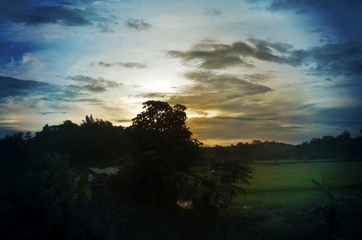 A colorful sunup above a small train station in thailand 