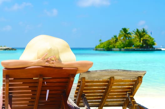 Woman on sunbed relaxing  at tropical  Maldives island. Travel and Vacation. 