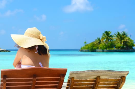 Woman on sunbed relaxing  at tropical  Maldives island. Travel and Vacation. 